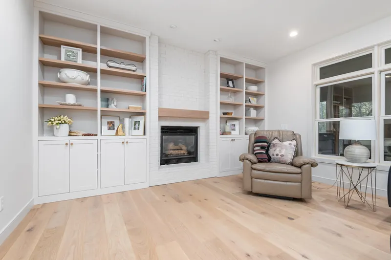 Wide-plank white oak hardwood in a living room with built-in shelves and a fireplace, installed by Anton's Floorcovering in Bloomington, MN