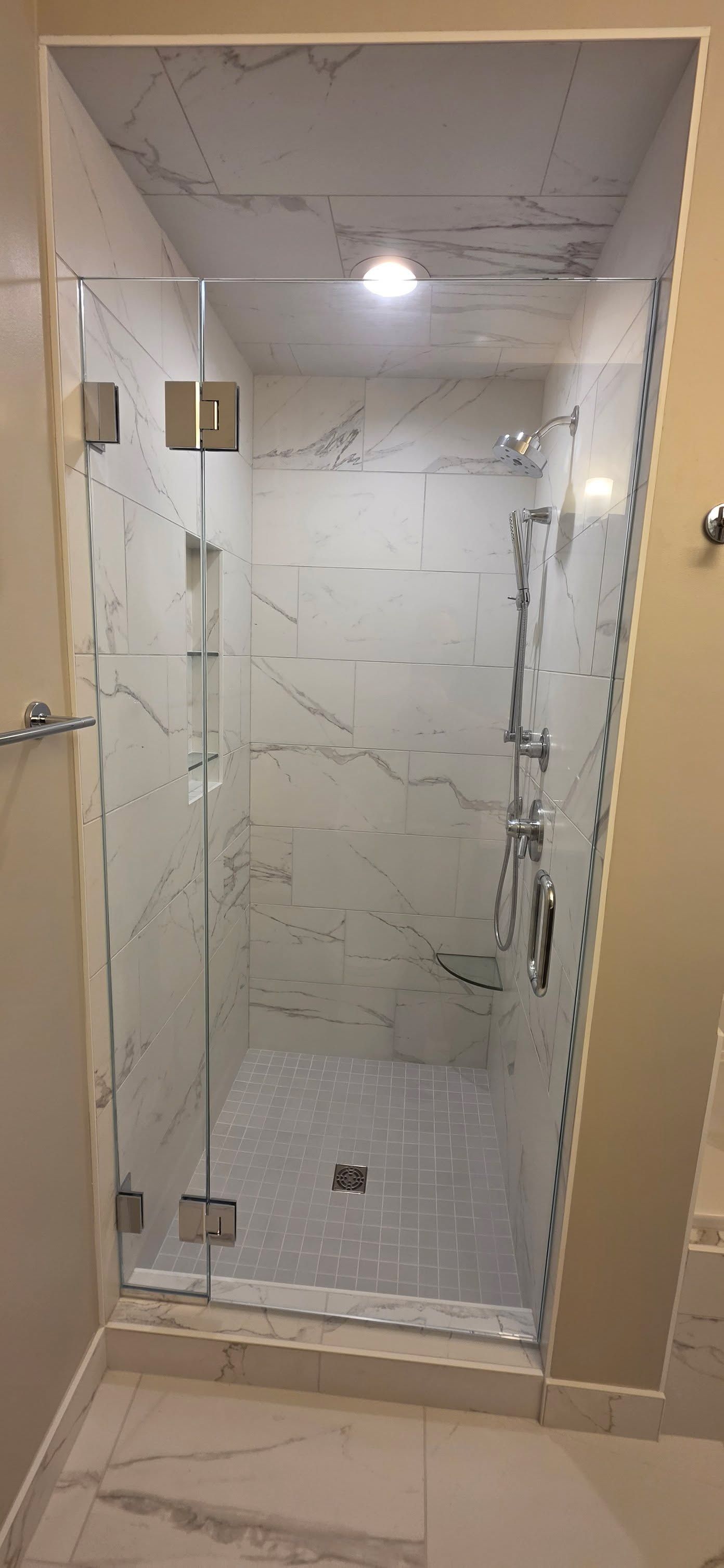 Primary bathroom walk-in shower with marble-look tile