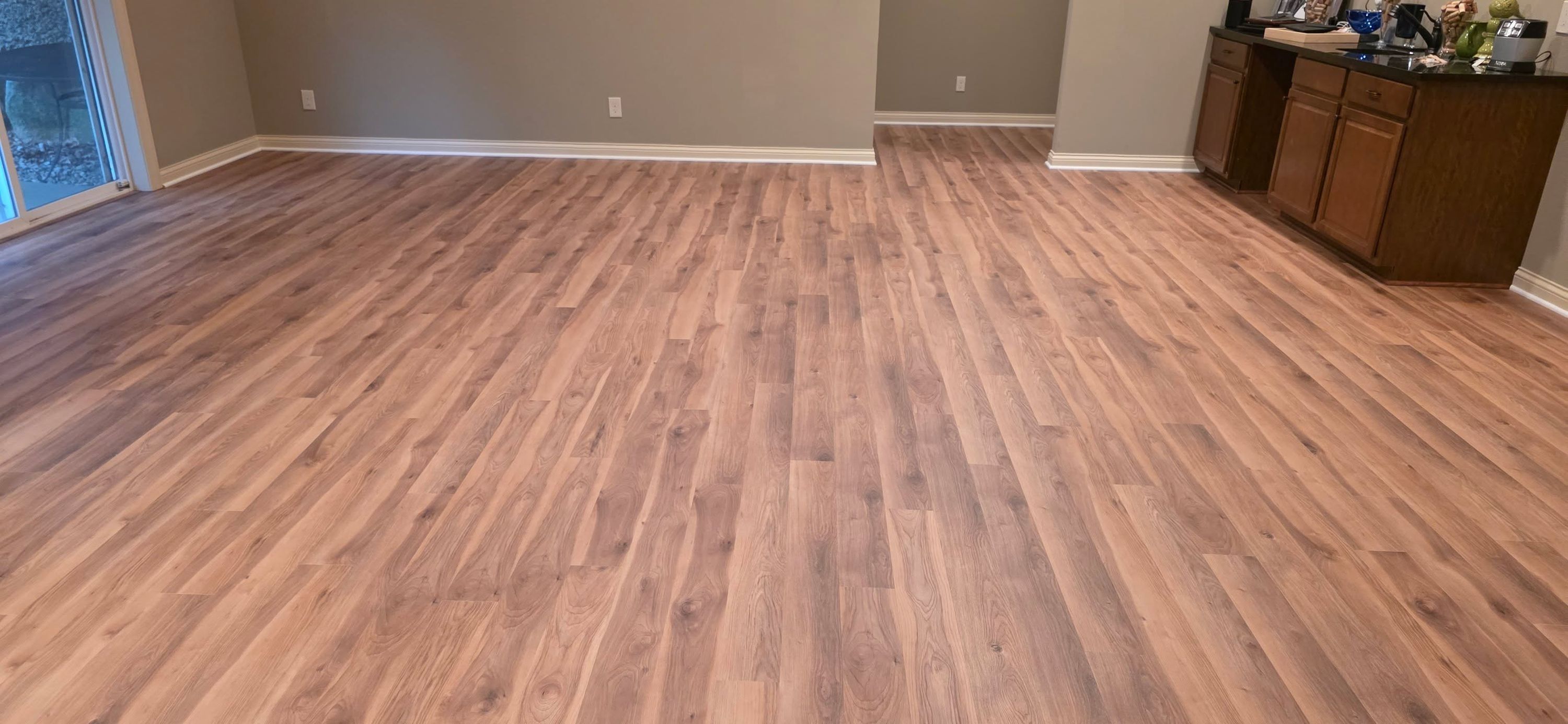 Living room with medium brown plank luxury vinyl flooring installed throughout the space.