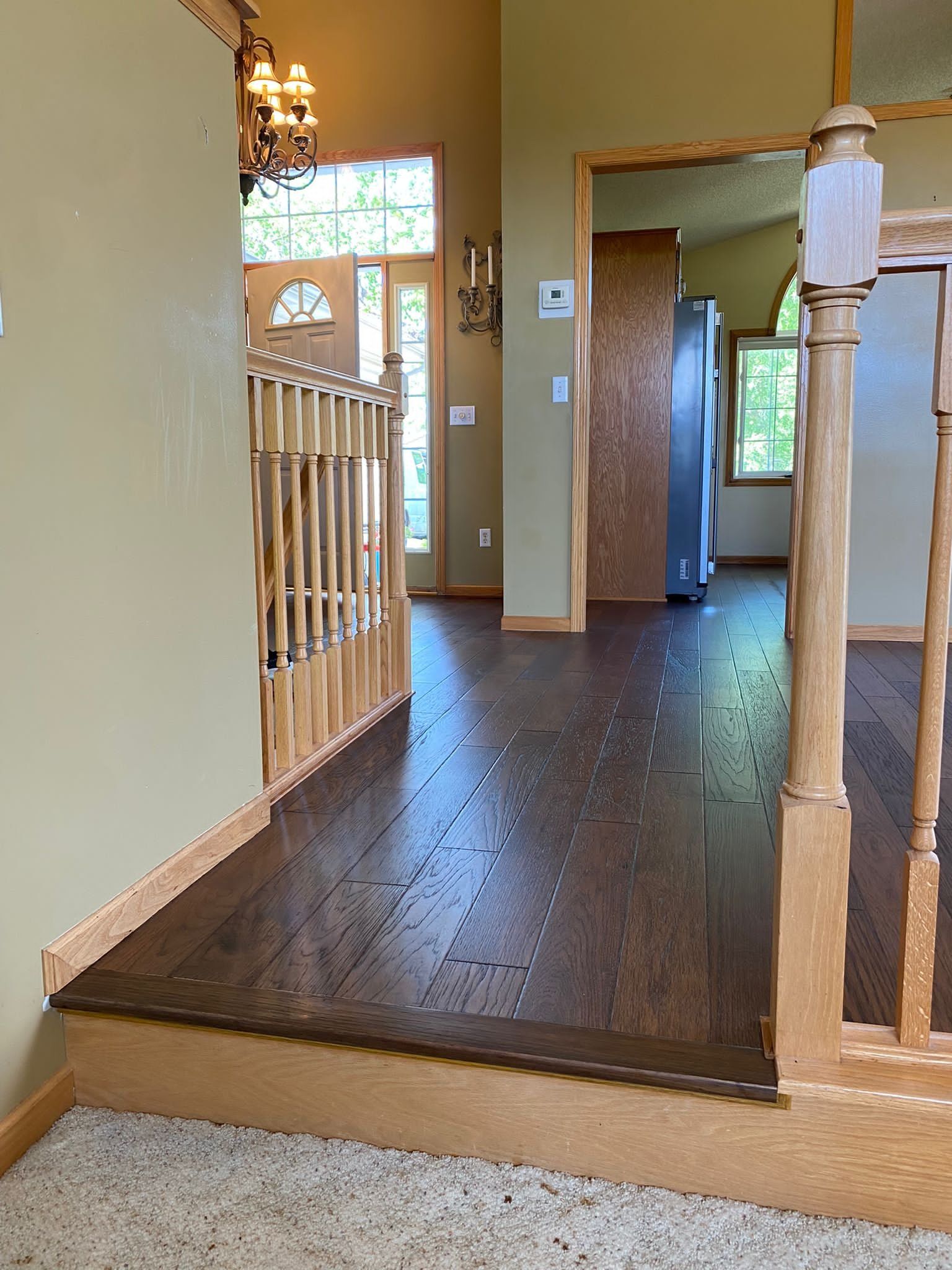 Entry hallway with dark hardwood plank flooring and light wood trim.