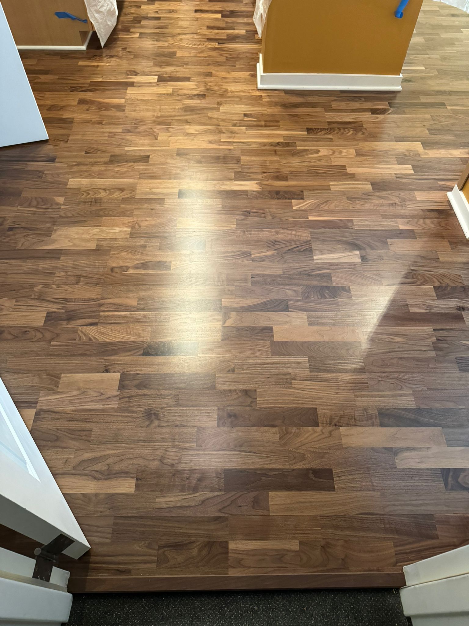Hardwood flooring with varied brown tones installed in a residential space during construction.