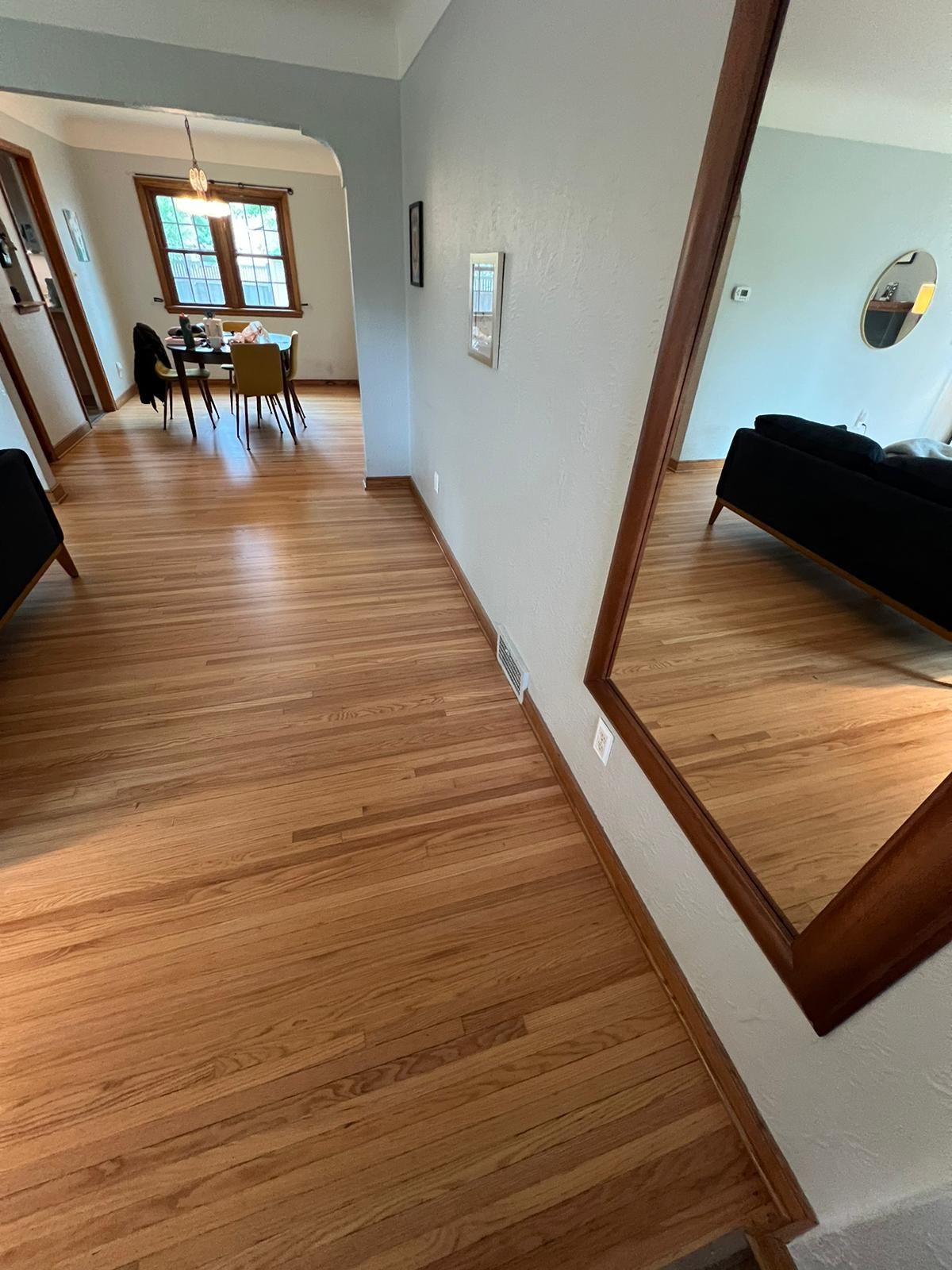 Hallway with refinished red oak hardwood flooring and matching wood trim throughout.